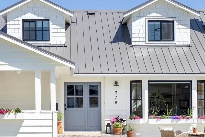 White farmhouse exterior with James Hardie siding and metal roof