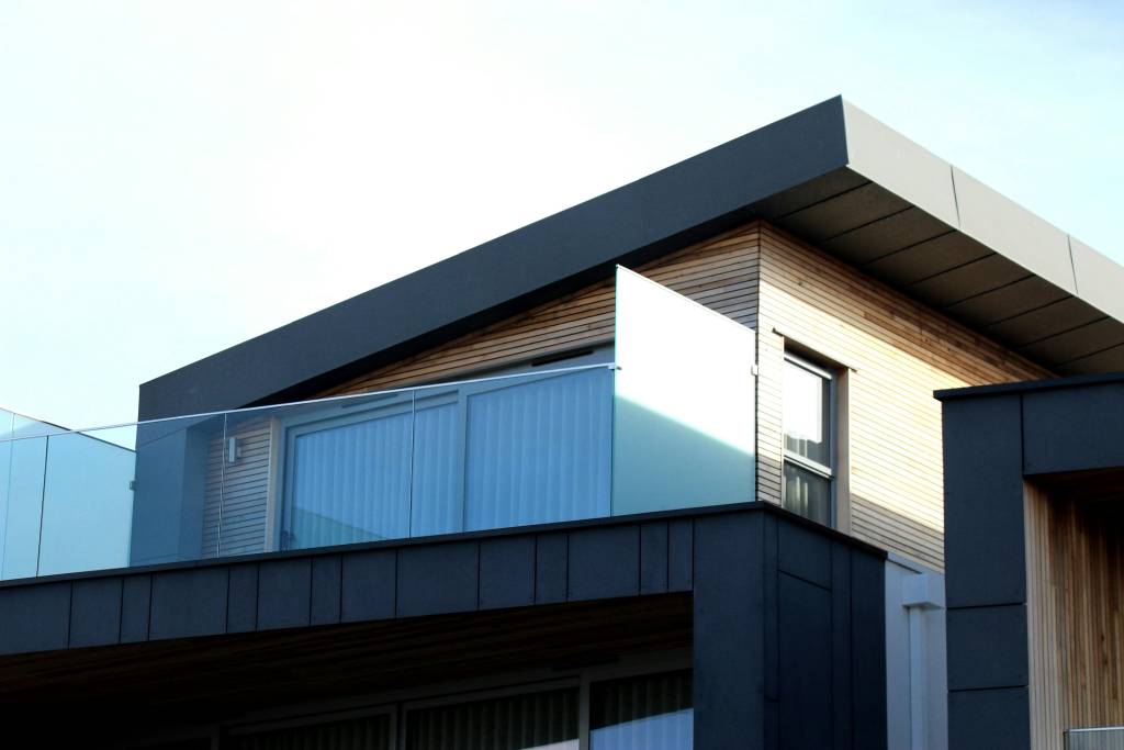 Modern home exterior with dark metal siding and wood cladding