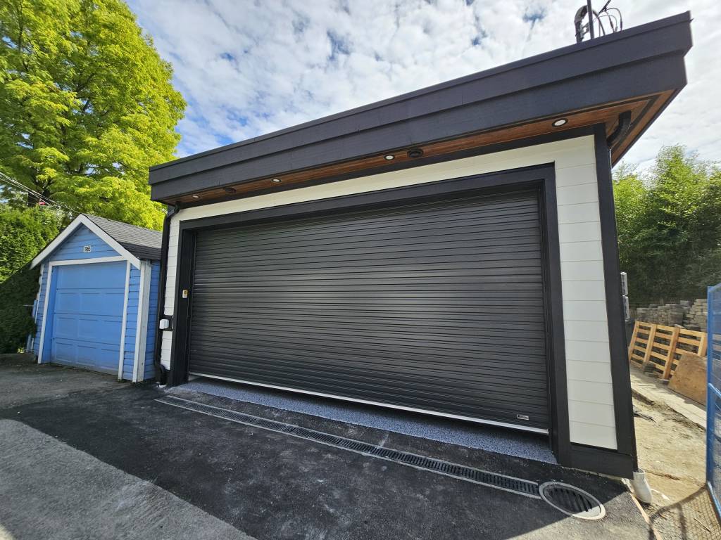 Detached garage with new siding and dark roll-up door