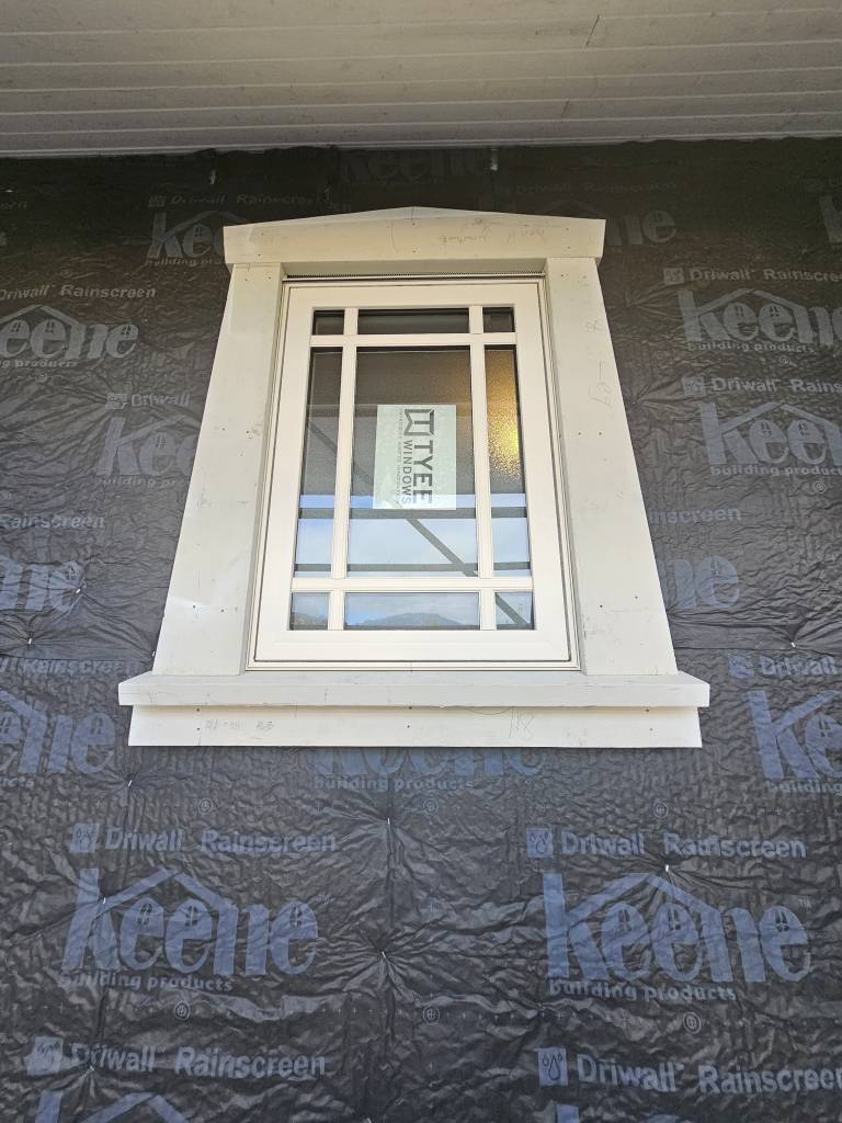 Newly installed window with exterior trim before siding
