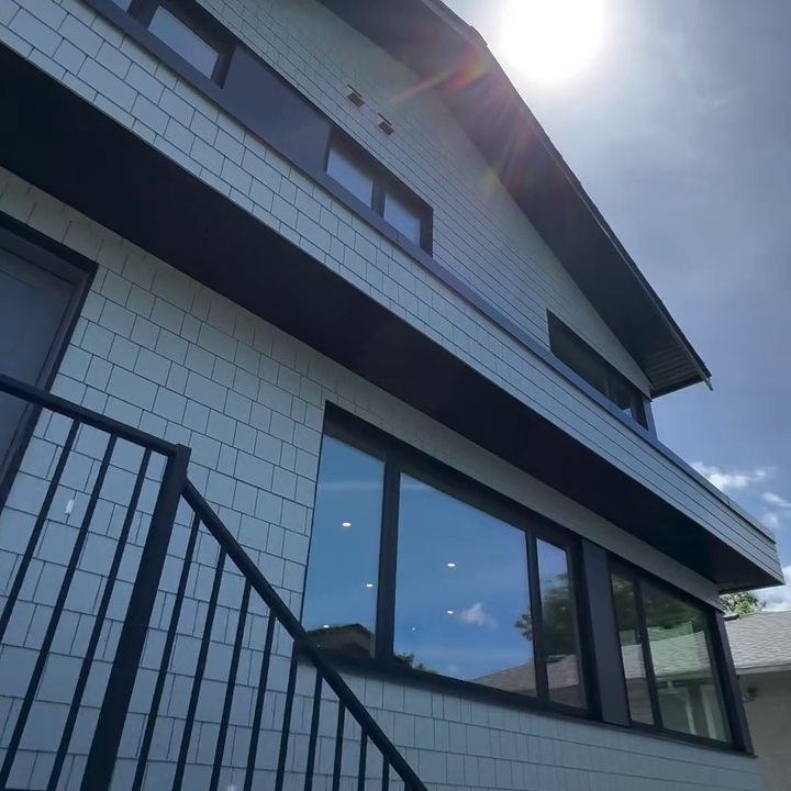 Looking up at shingle siding and windows on a Net Zero home